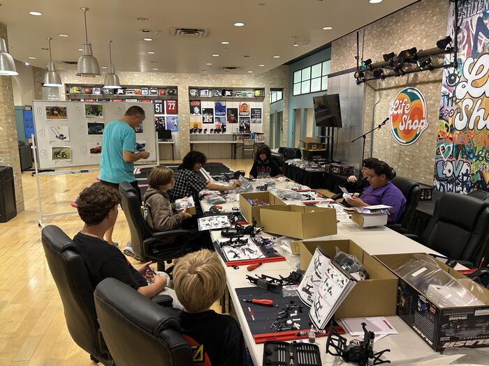Teens building RC kits together at the class tables
