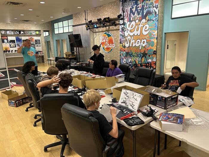Teens working through their RC kits at the long tables