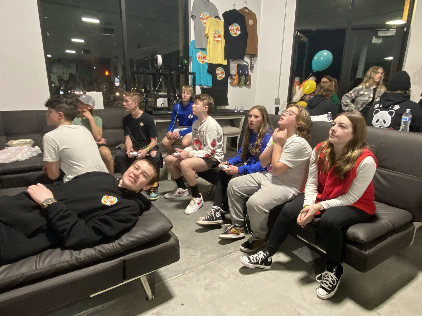 Teens sitting together on the couches at Life Shop listening during a class