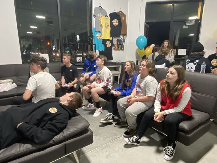 Teens sitting along the couches listening in during a Life Shop session