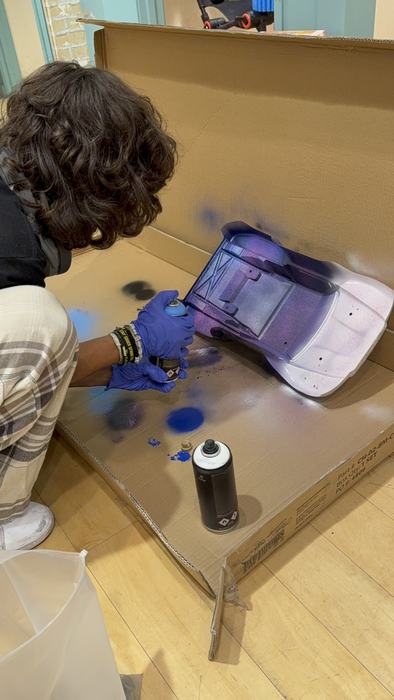 A teen finishing the paint on a custom RC body